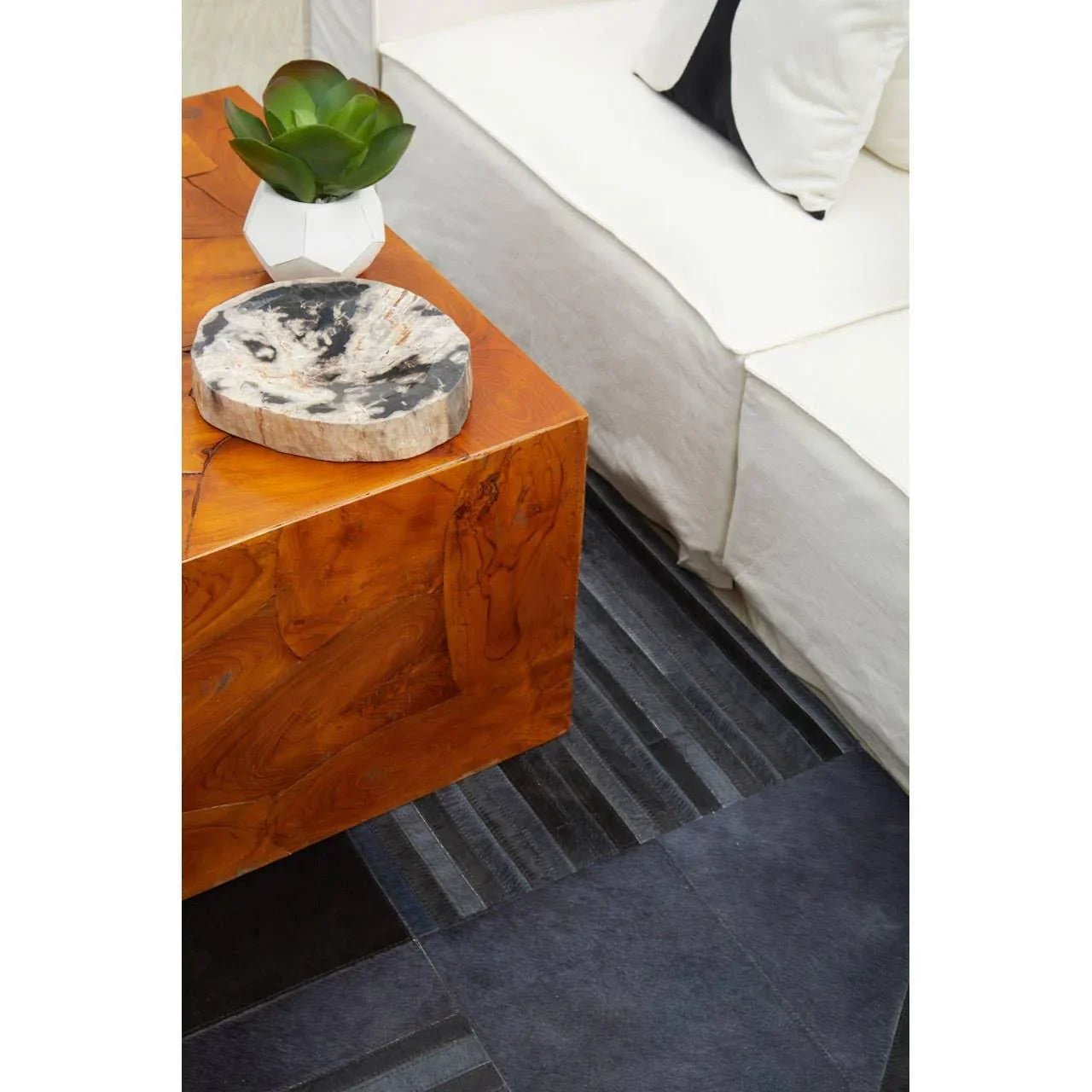 White sofa beside wood coffee table with marble decor and geometric plant pot