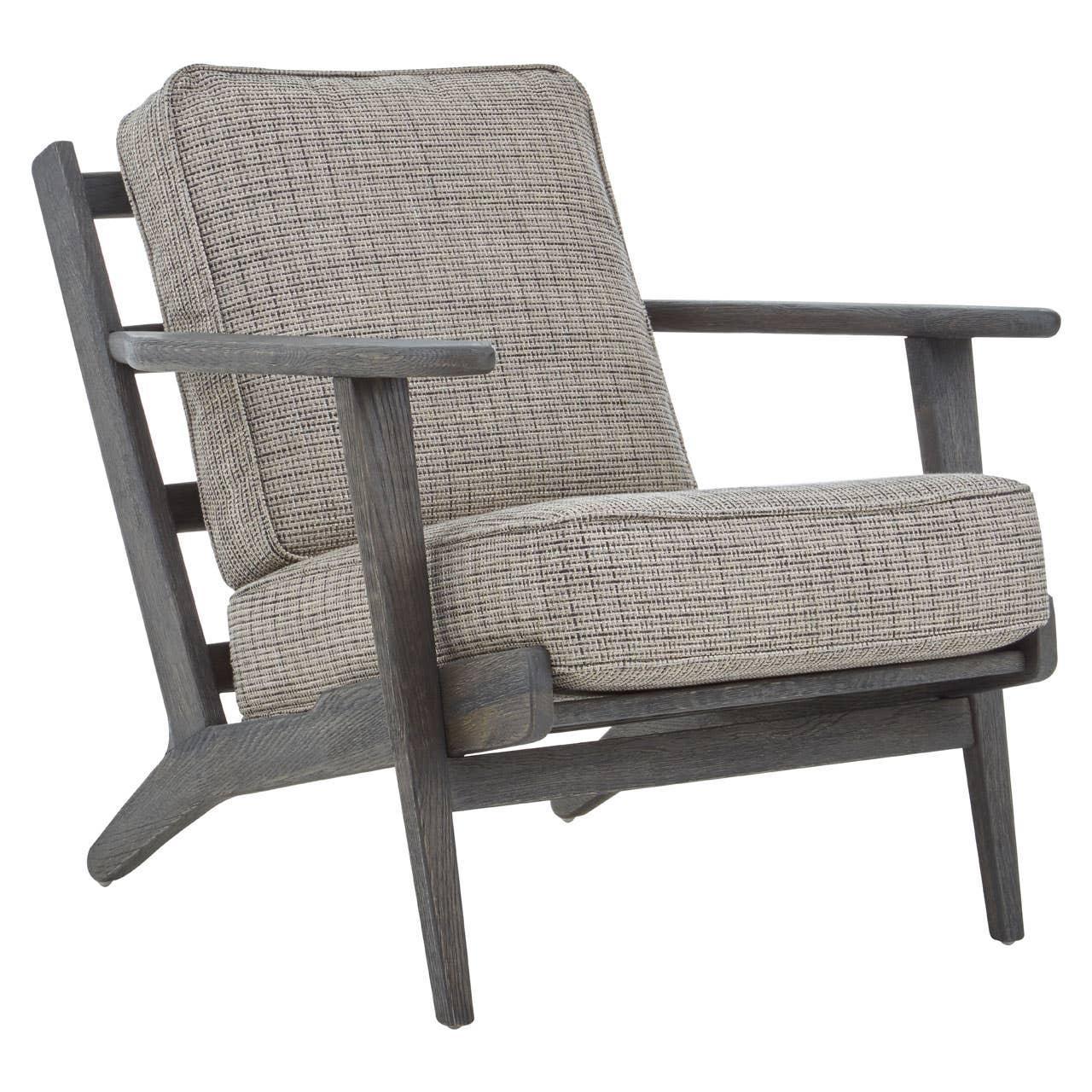 Grey wooden armchair with textured upholstered cushions and angled legs