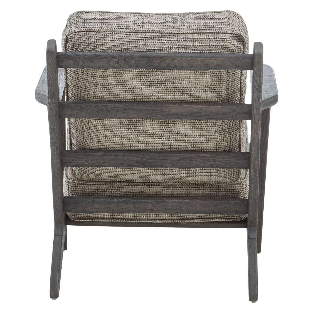 Back view of wooden armchair with grey cushioned seat and slatted frame