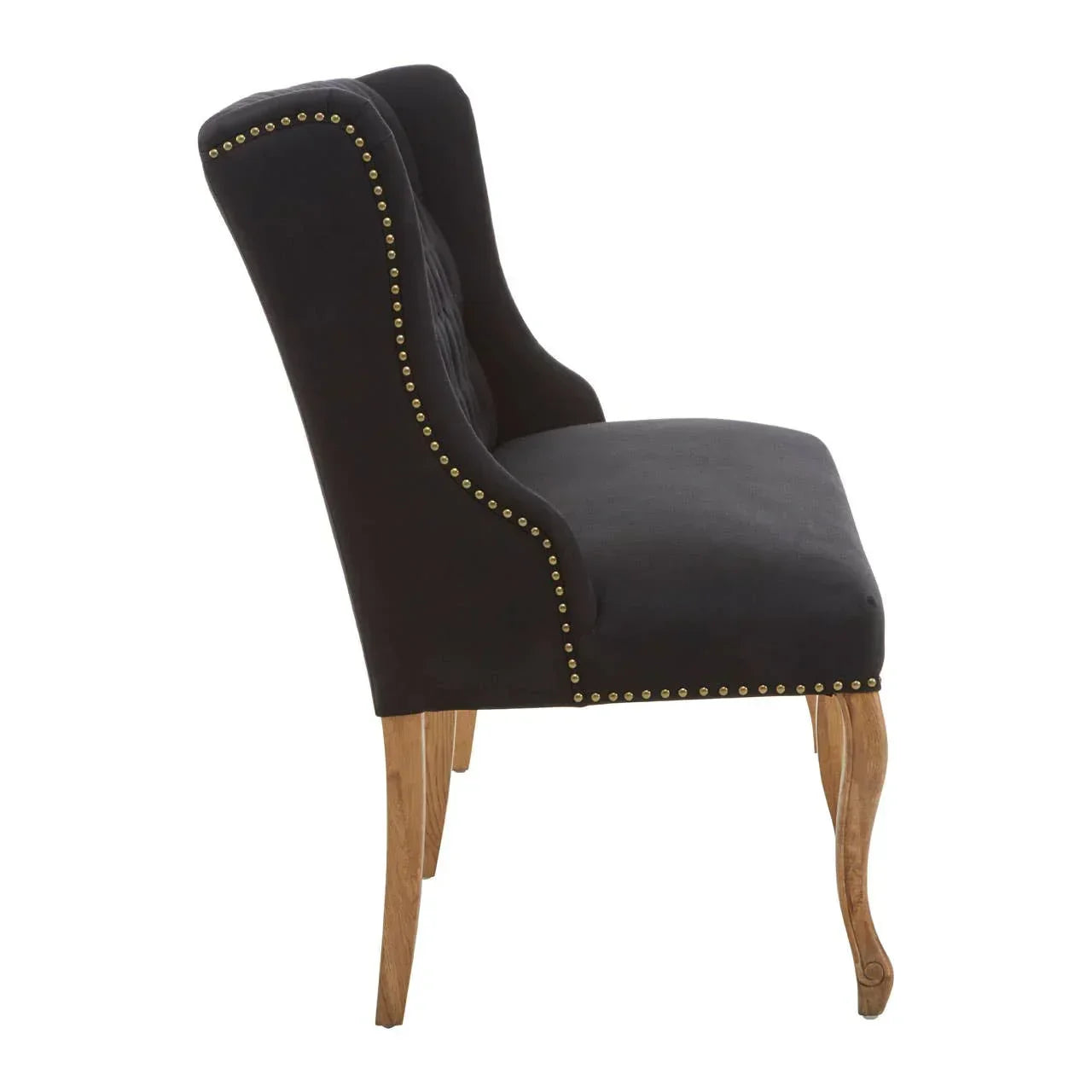 Black velvet dining chair with studded trim and wooden legs side view