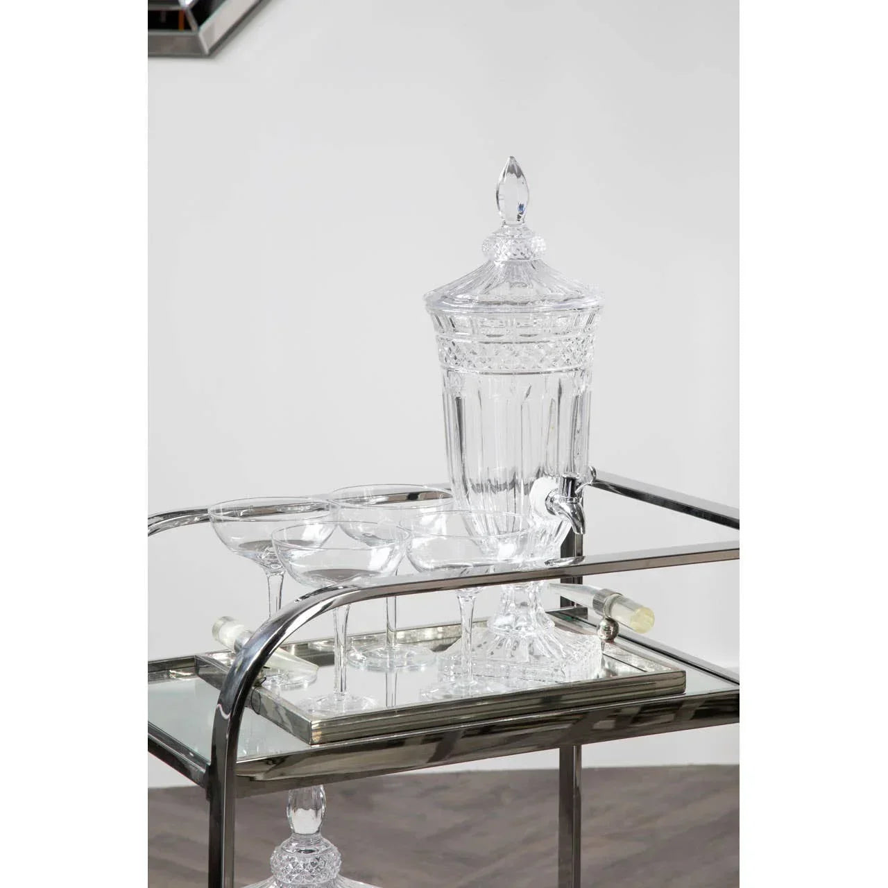 Glass drinks set with decanter and coupe glasses on mirrored drinks trolley