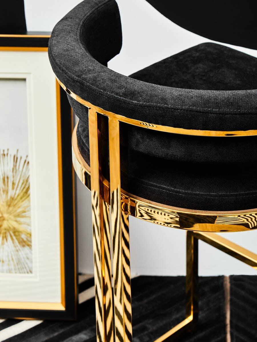 Black velvet bar stool with gold metal frame, modern design, close-up view