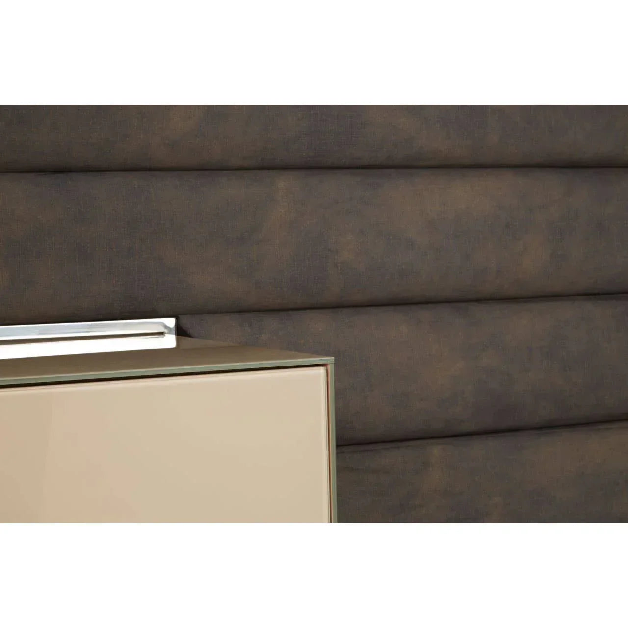 Beige bedside cabinet beside padded brown fabric headboard with modern panel design
