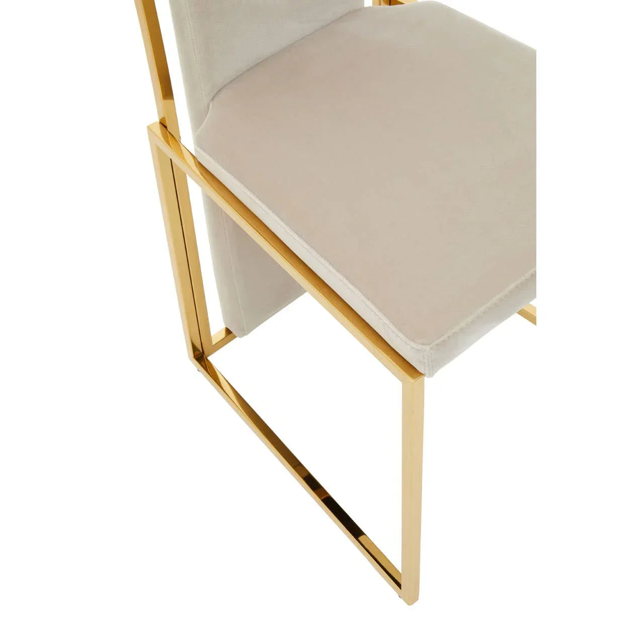 Velvet dining chair with gold metal frame and cream seat close-up
