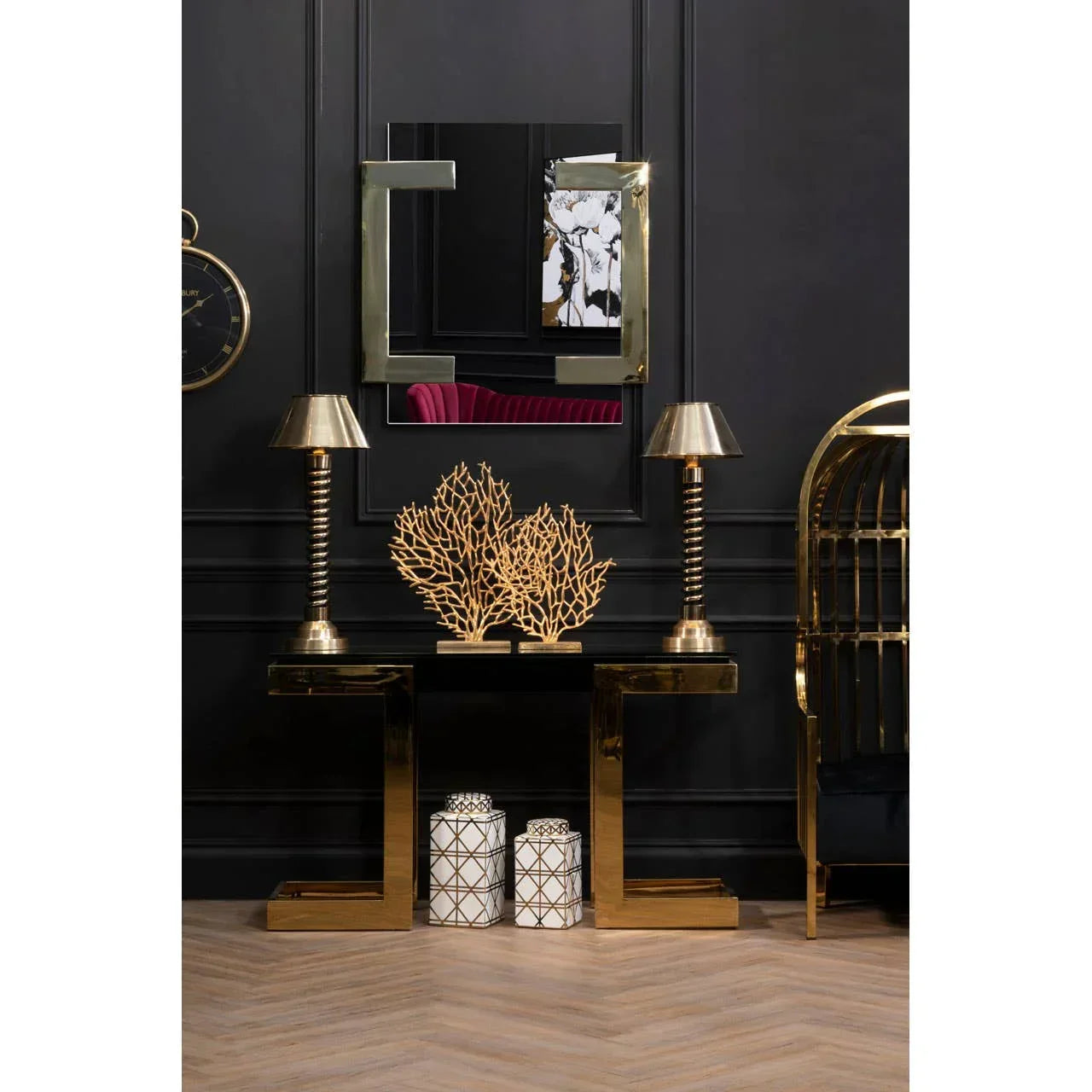 Gold console table with matching lamps, decorative coral sculpture, and ceramic jars in hallway