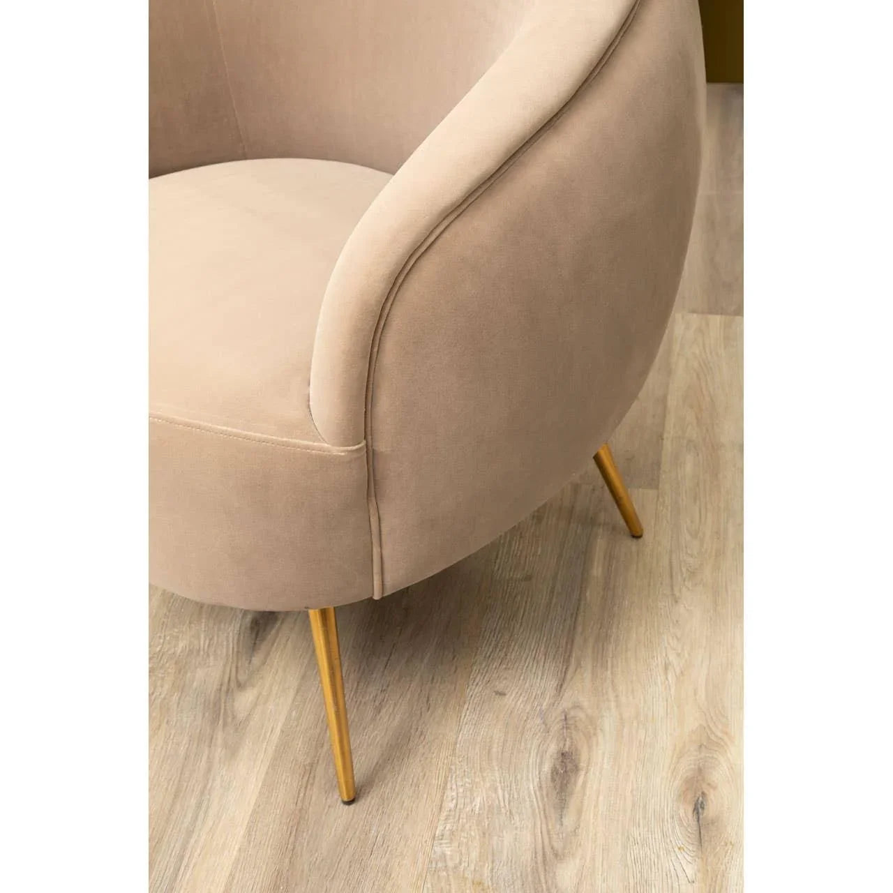 Beige velvet accent chair with gold metal legs on light wood flooring