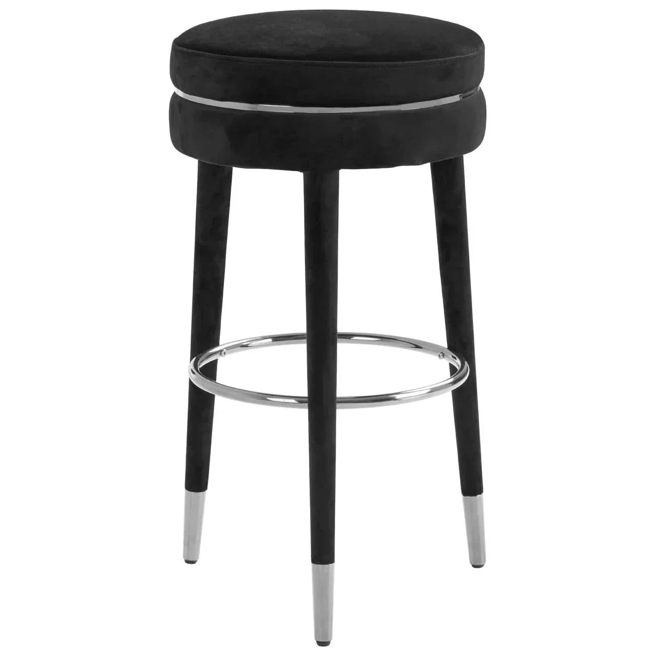 Black bar stool with round cushioned seat, metal footrest, and tapered legs