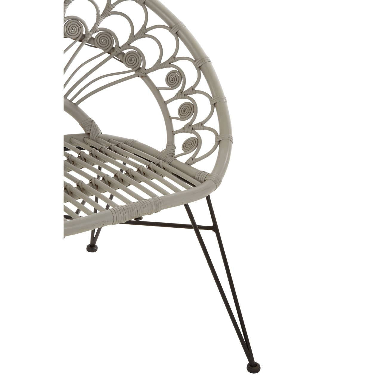 A grey natural rattan chair with a curved backrest featuring a decorative pattern, supported by slender black metal legs. The chair's seat is woven with rattan, showcasing a light and airy design suitable for indoor or outdoor use