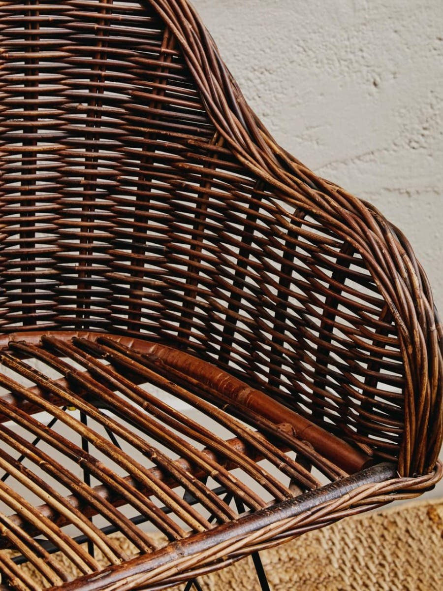 A close-up view of the Manado Natural Croco Rattan Chair, showcasing its intricate woven design and natural brown tones. The chair features a curved backrest and a sturdy seat made from rattan, highlighting the craftsmanship and texture of the material against a neutral background