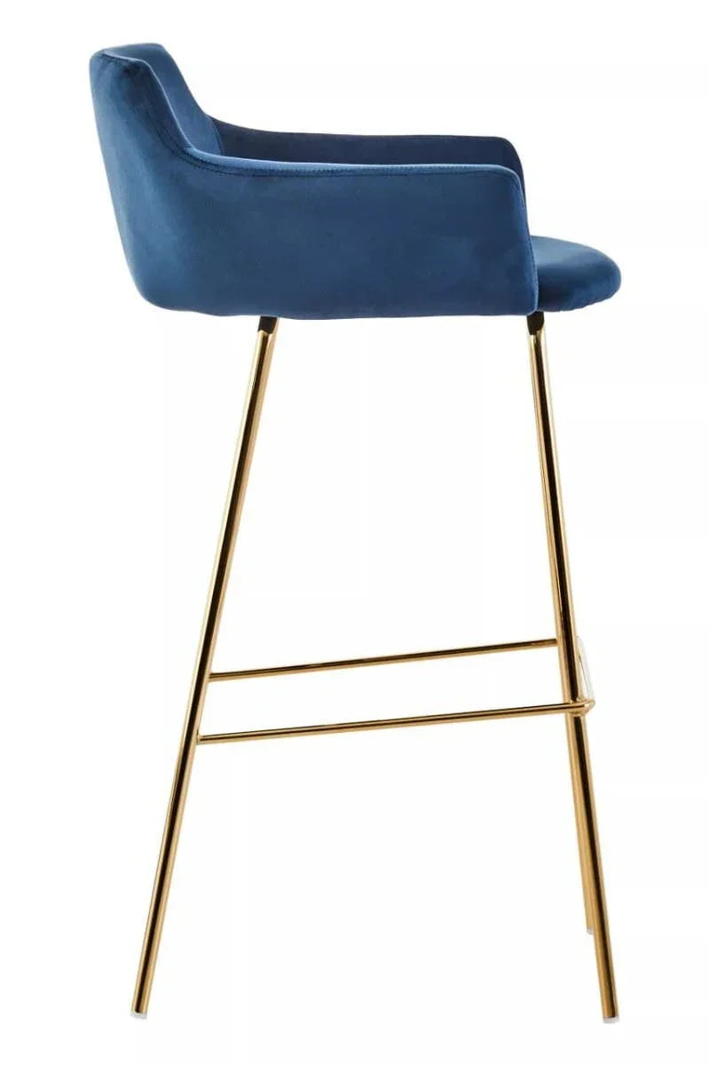Blue velvet bar stool with gold metal legs and footrest, side profile view