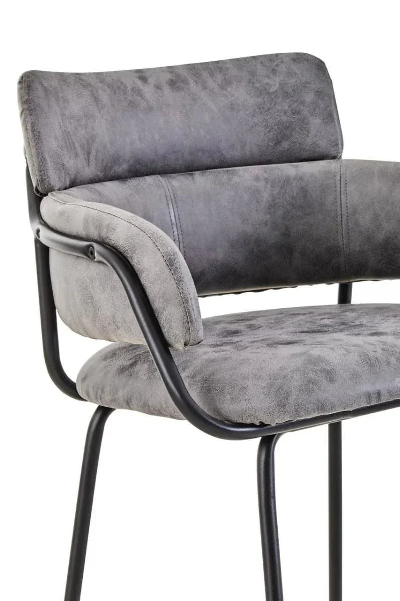 Grey velvet dining chair with cushioned seat and black metal frame, side angle view