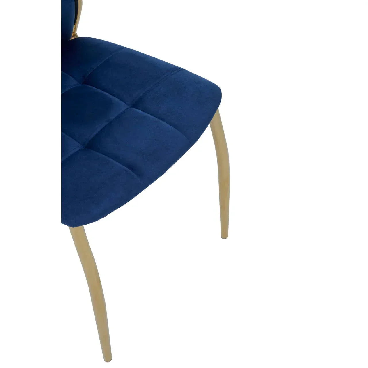 Navy blue velvet dining chair with square stitching and gold metal legs, side angle view