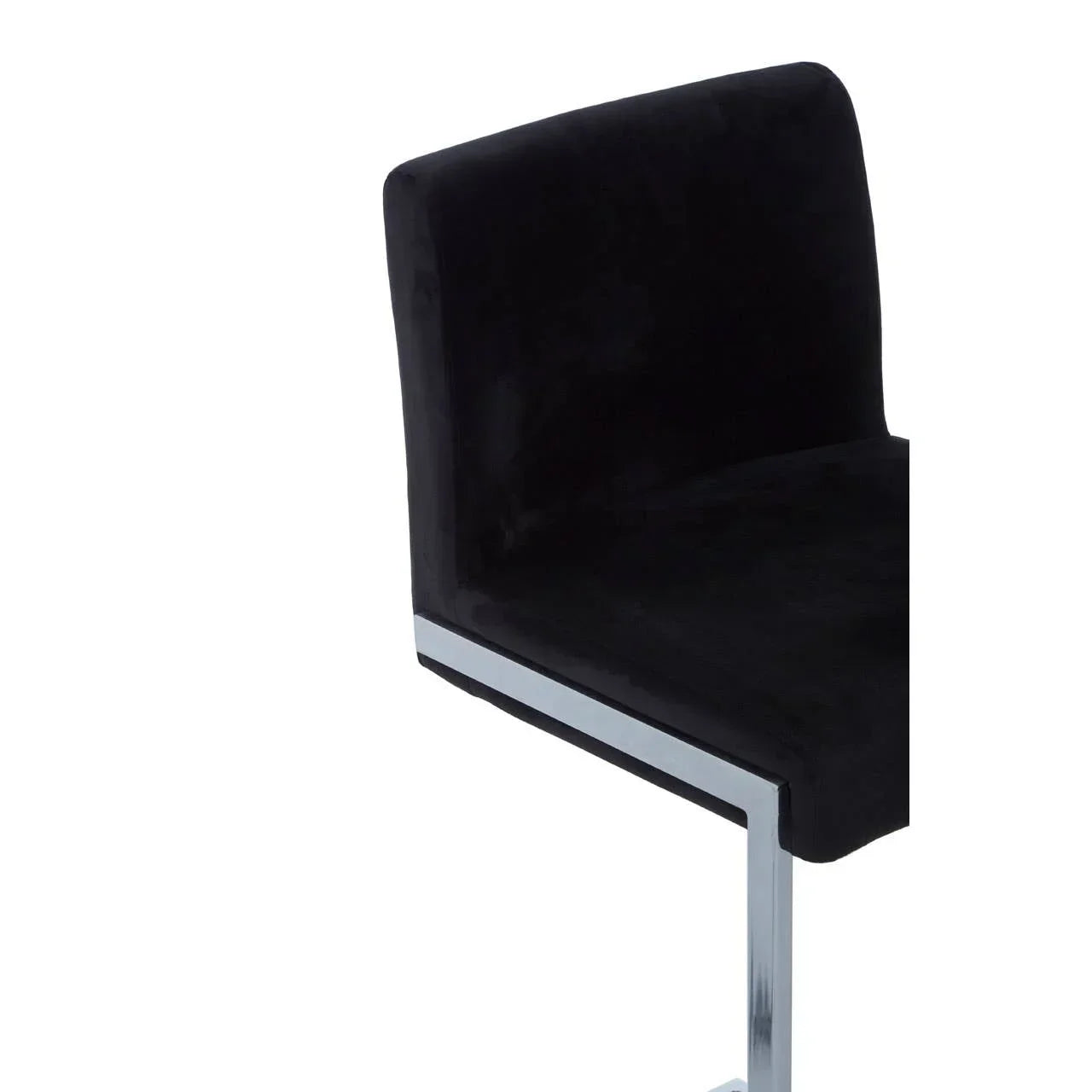 Black velvet dining chair with chrome legs, side angle close-up
