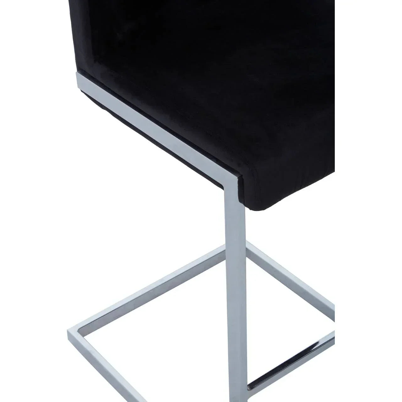 Black velvet dining chair with chrome metal leg frame, close-up of seat and base