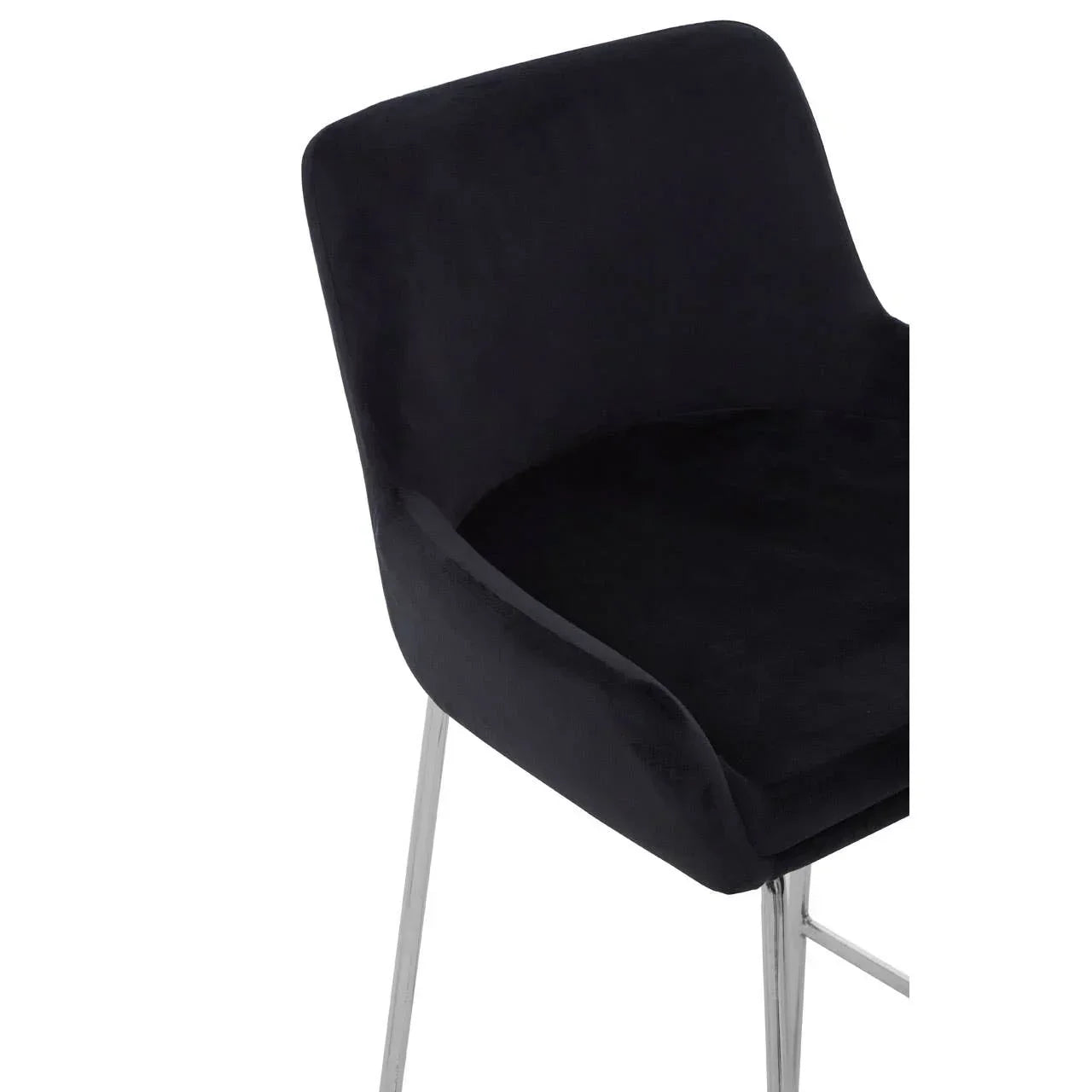 Black velvet dining chair with chrome legs, close-up of curved seat and backrest