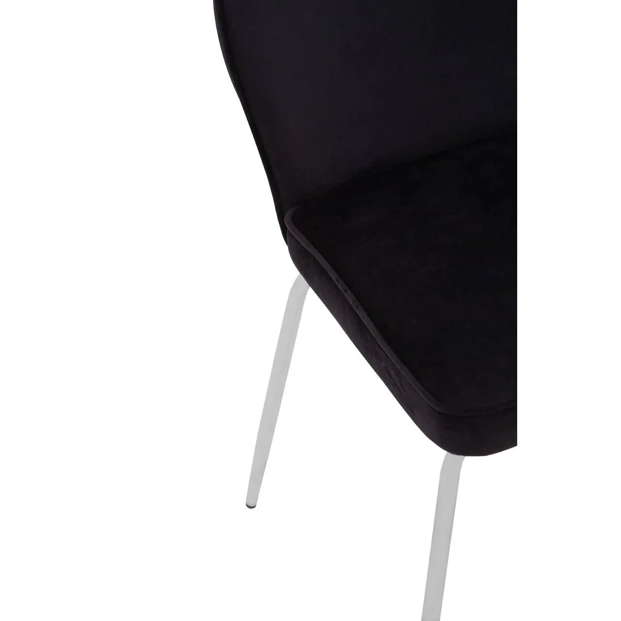 Black velvet dining chair with chrome legs, partial close-up of seat and back