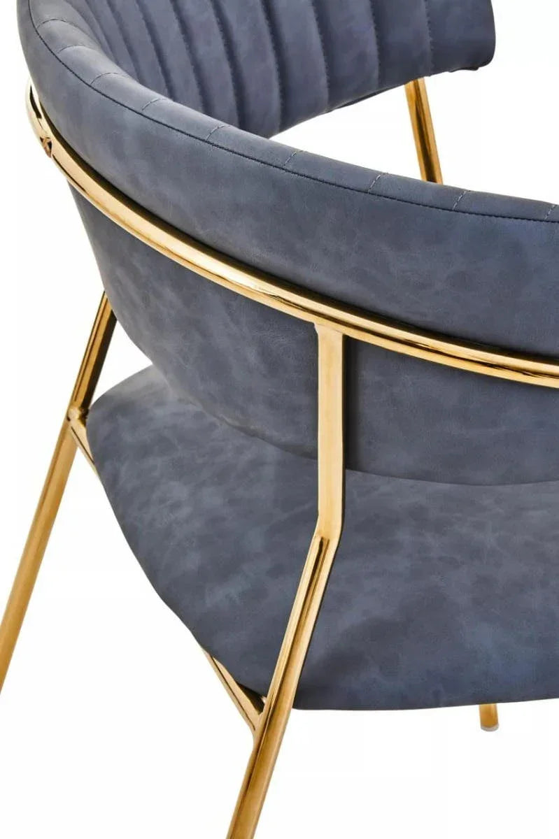 Navy velvet dining chair with gold metal frame and curved backrest close-up