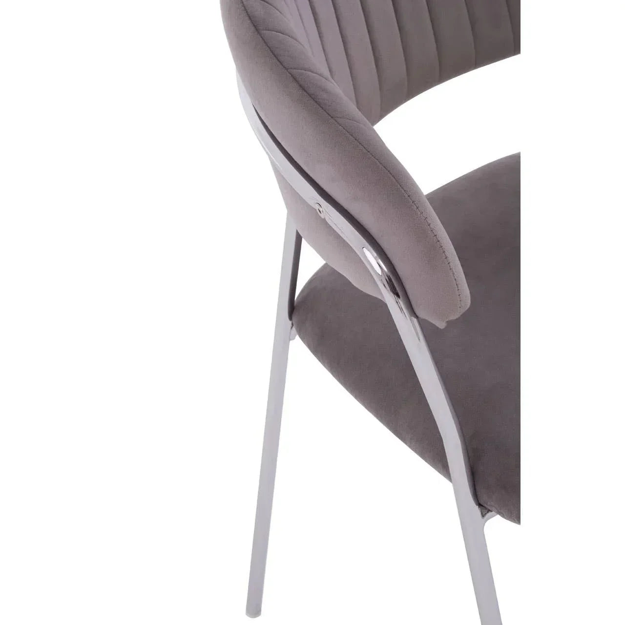 Grey velvet dining chair with chrome legs, showing curved backrest and stitched detailing