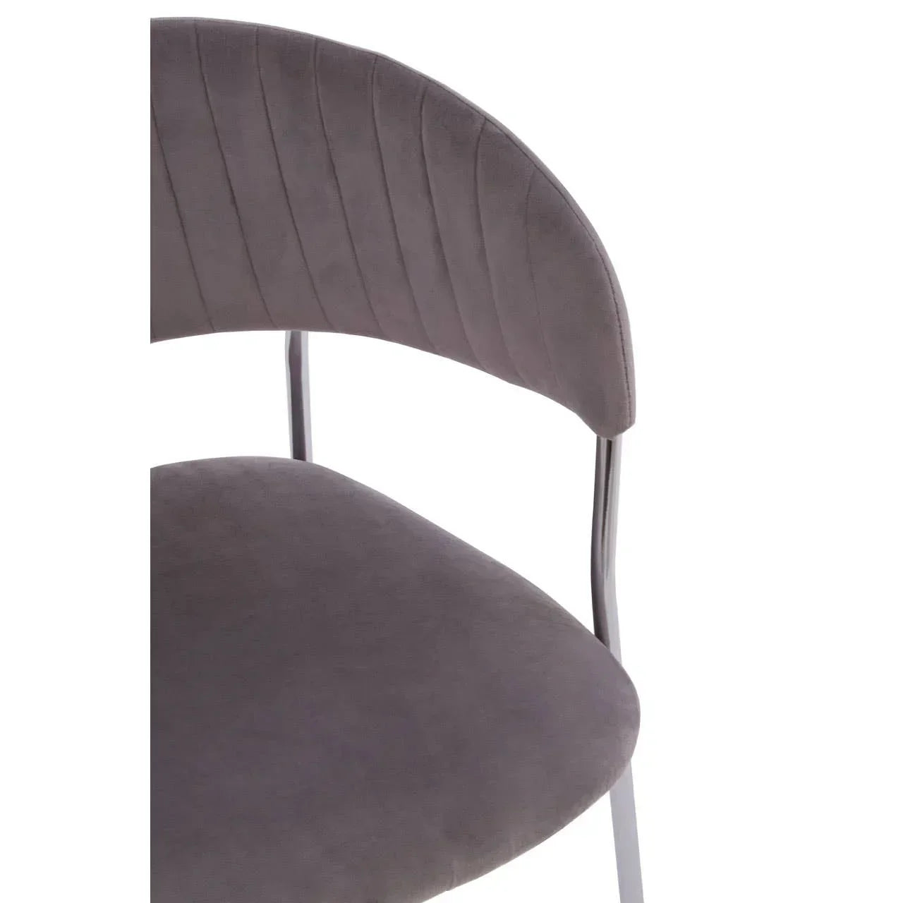 Grey velvet dining chair with curved backrest and chrome legs close-up