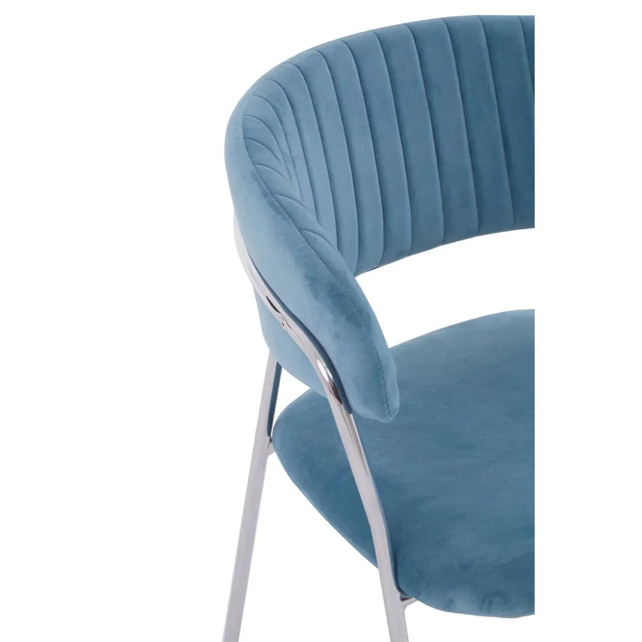 Blue velvet dining chair with curved backrest and chrome legs, partial side view