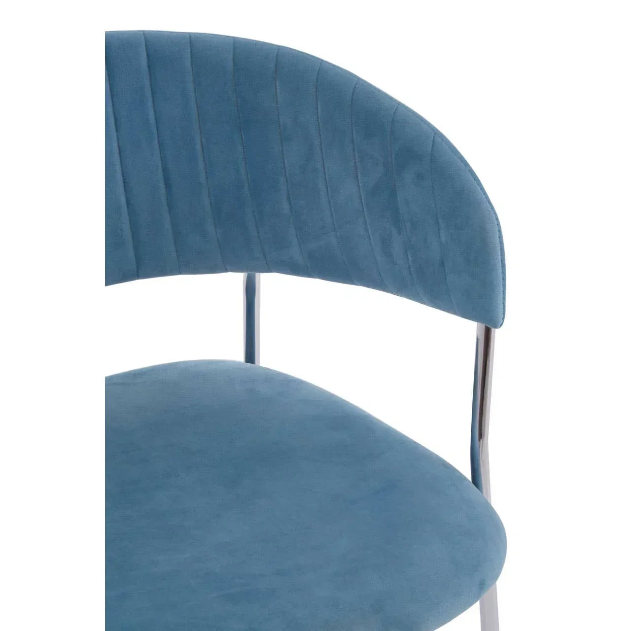 Blue velvet dining chair with curved backrest and chrome legs close-up