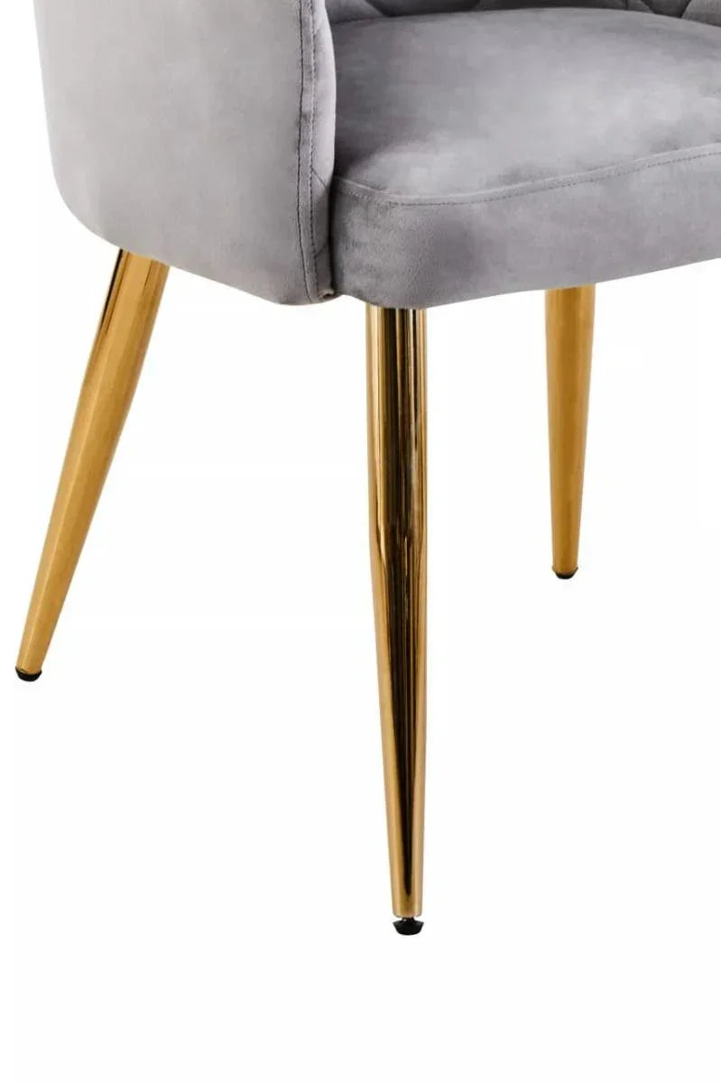 Grey velvet dining chair with gold metal legs, close-up on seat and leg details