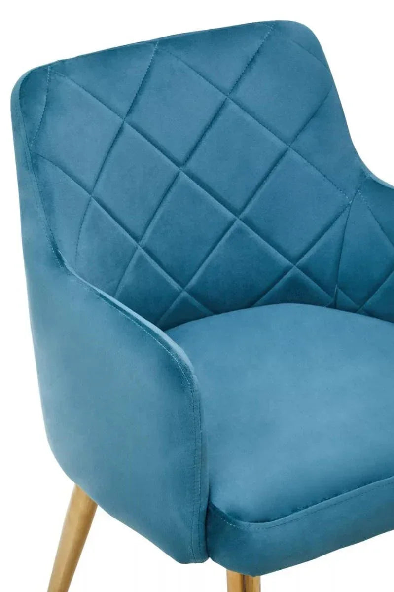 Blue velvet dining chair with quilted backrest and light wood legs, close-up view