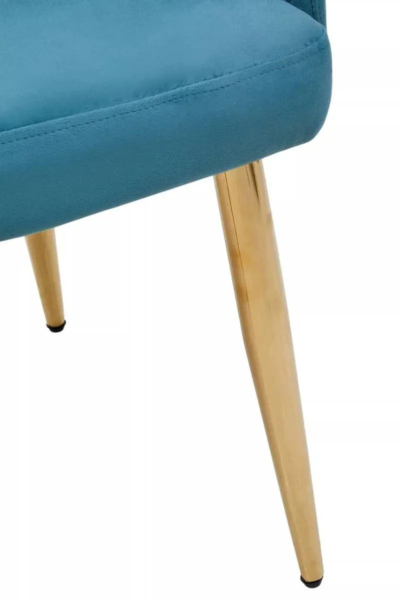 Close up of teal dining chair seat with gold metal legs