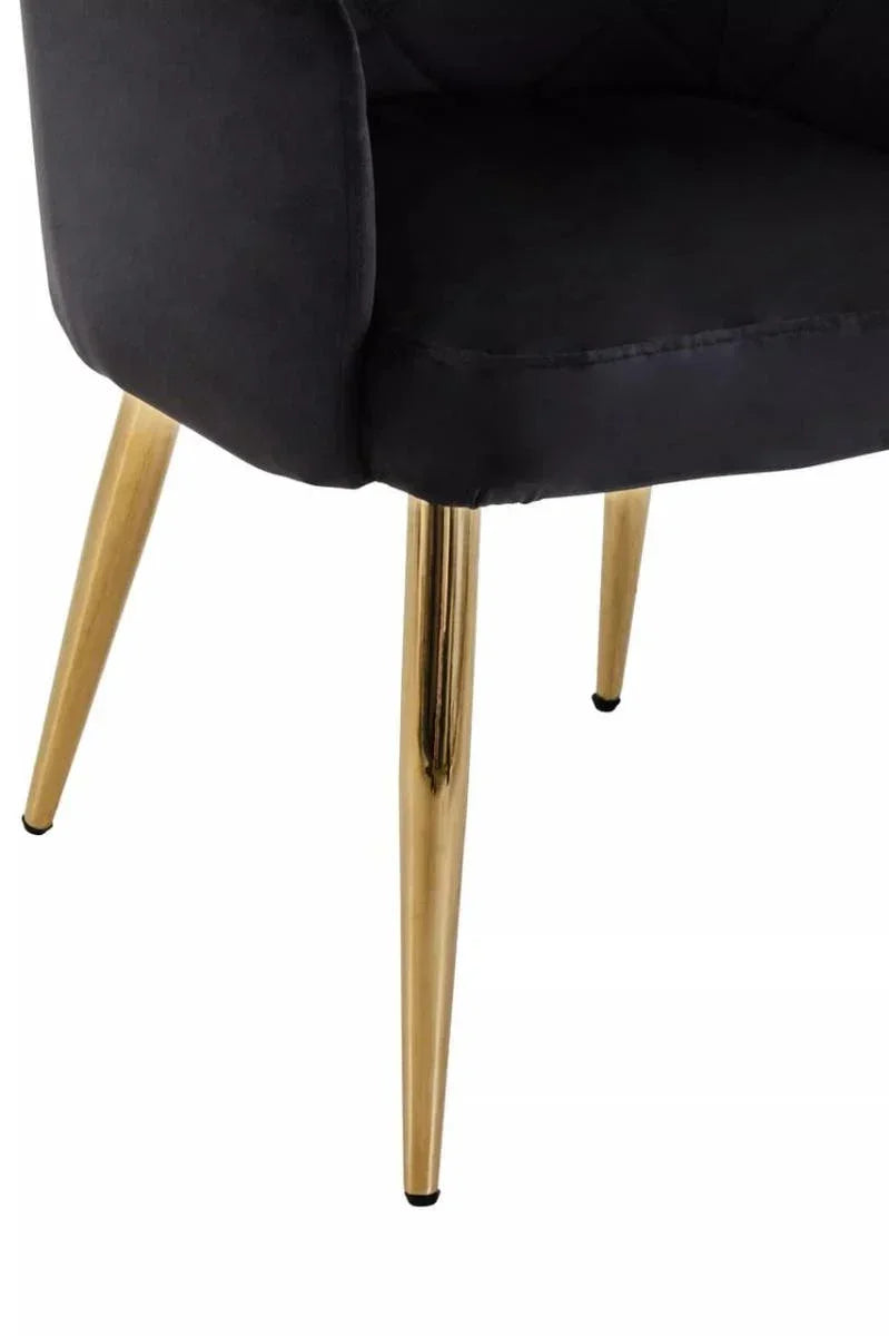 Black velvet chair with gold metal legs, close-up on lower seat and leg detail