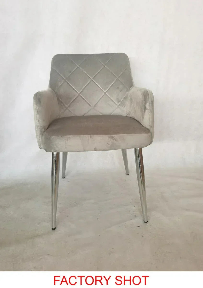 Grey velvet dining chair with quilted backrest and chrome legs, factory background