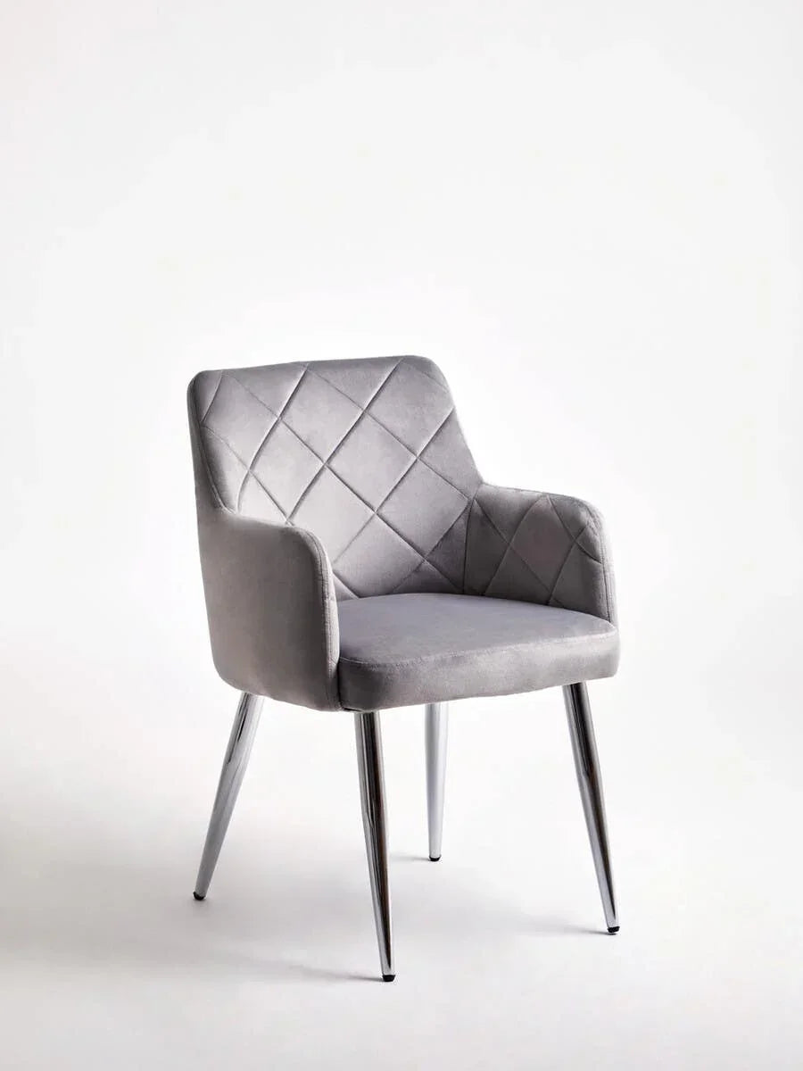 Grey velvet dining chair with quilted backrest and chrome legs on white background
