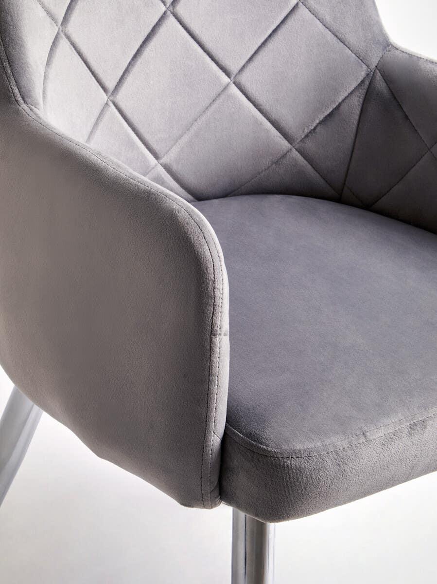 Grey velvet dining chair with quilted backrest and chrome legs, close-up view