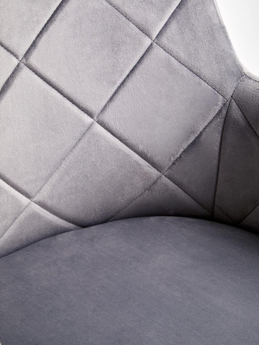Close-up of grey velvet chair with diamond stitching on backrest