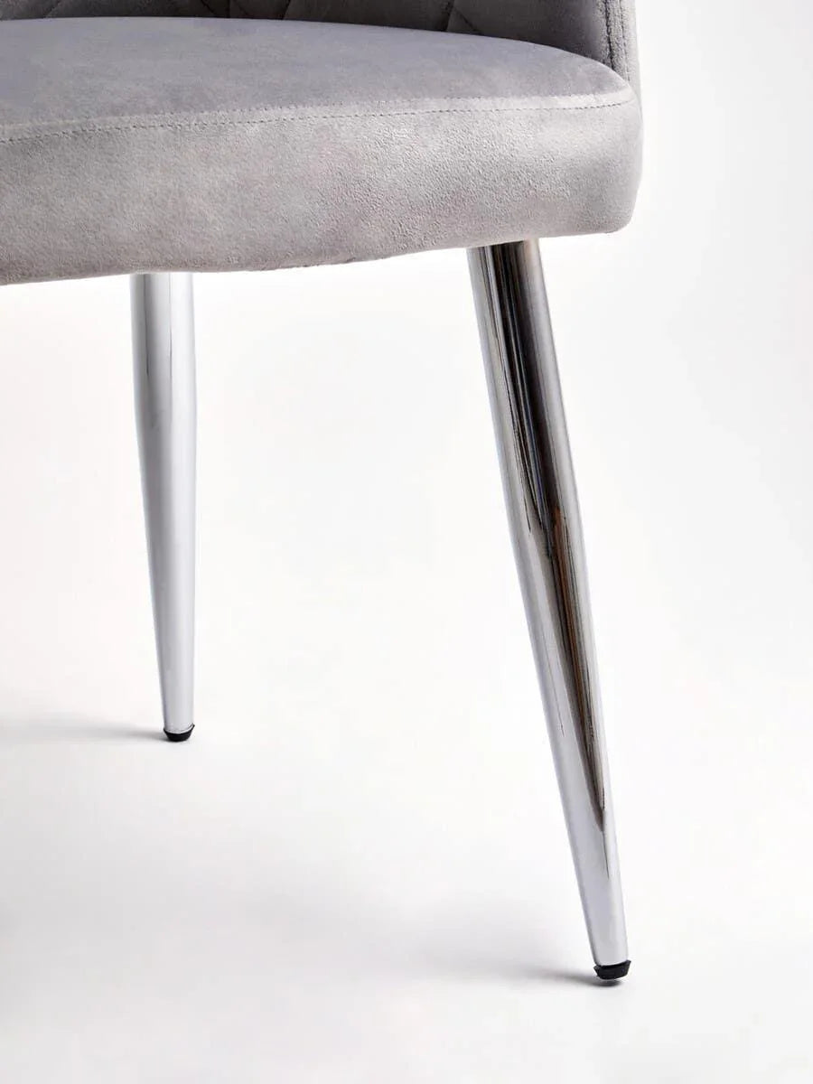 Closeup of grey upholstered chair seat with chrome metal legs