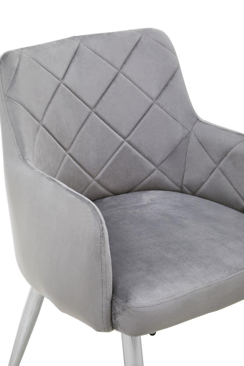 Grey velvet dining chair with quilted backrest and white angled legs, close up view