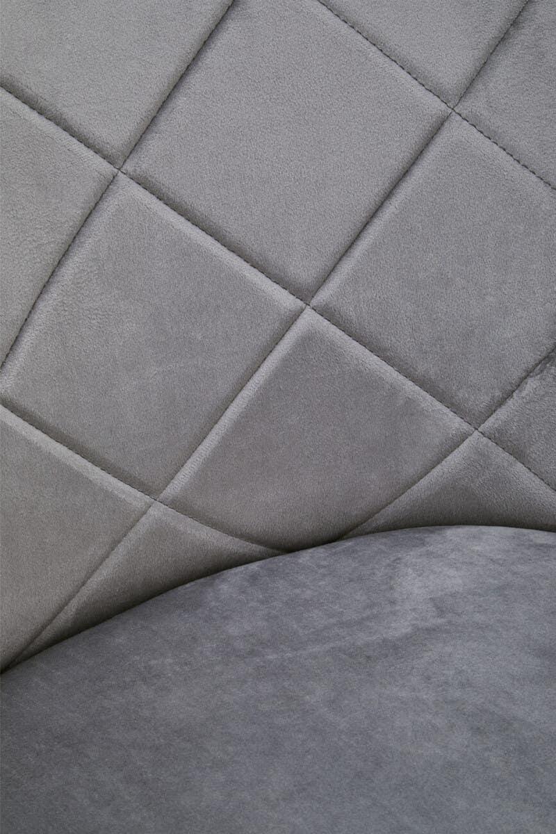 Grey velvet chair closeup with quilted diamond stitching and curved backrest