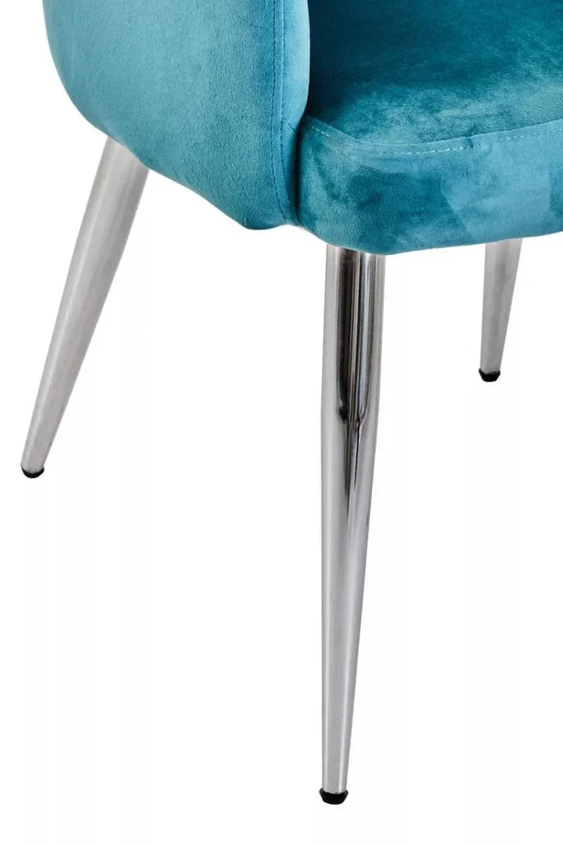 Teal velvet chair seat with chrome angled legs, close-up focus on upholstery and frame