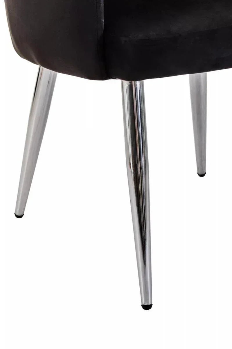 Close-up of chrome dining chair legs with black upholstered seat