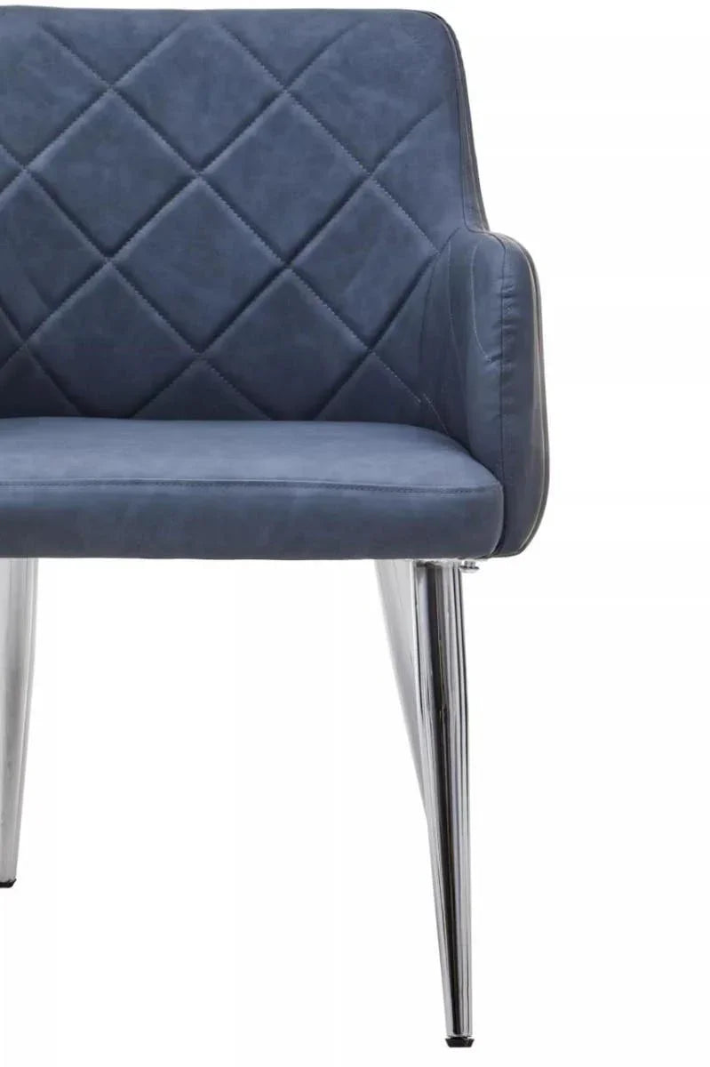 Blue velvet dining chair with quilted backrest and chrome tapered legs, close-up view