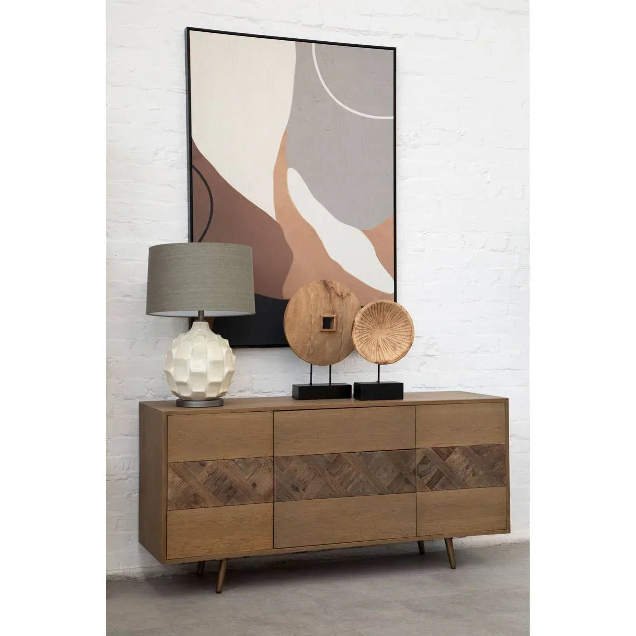 Modern oak sideboard with geometric drawers, ceramic lamp and wooden decor in a living room