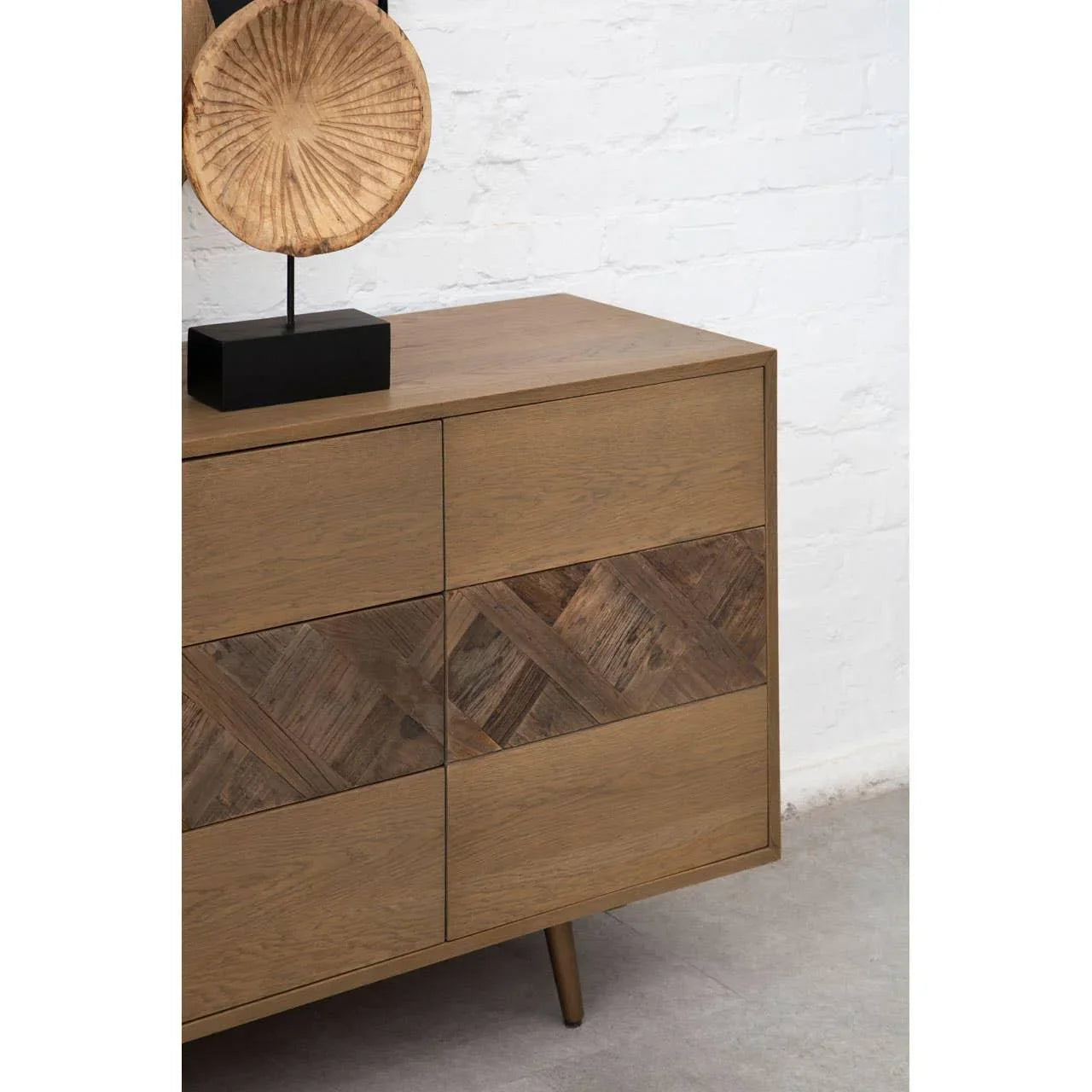 Brown wooden sideboard with chevron pattern drawers and decorative wooden sculpture