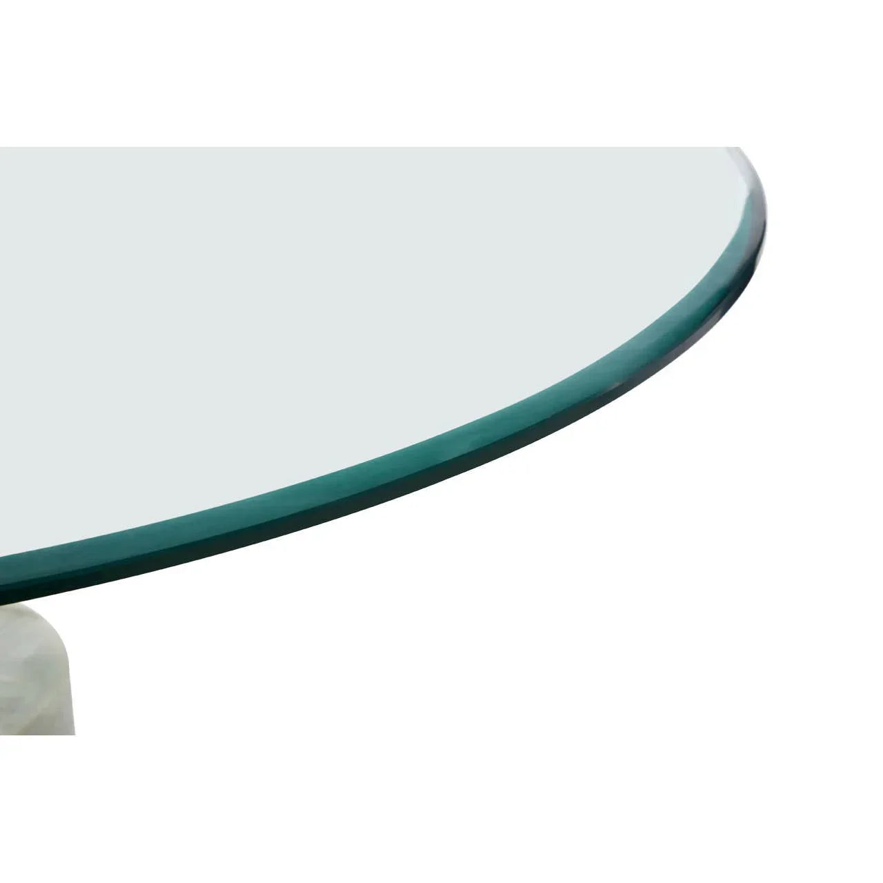 Closeup of round glass table top with beveled edge and marble base corner