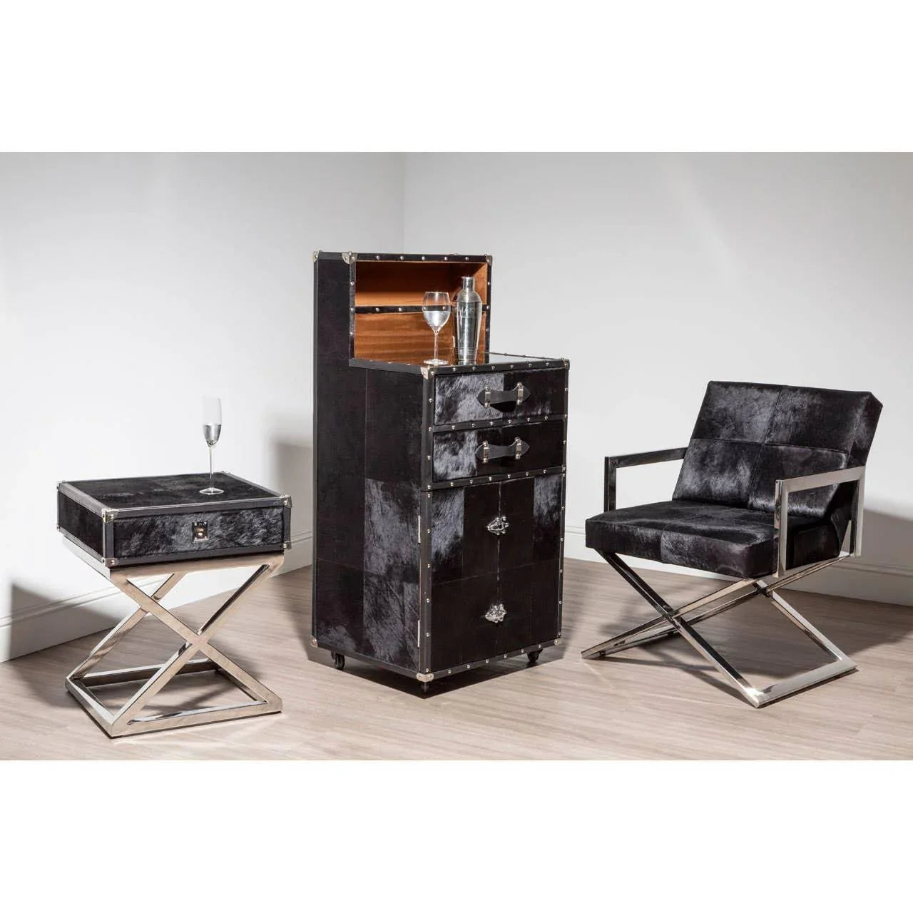 Black leather armchair, matching side table and drinks cabinet with chrome frame in modern room