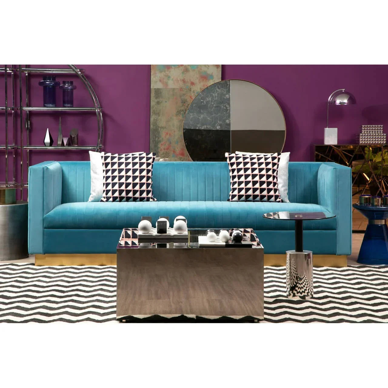 Blue velvet sofa with patterned cushions and mirrored coffee table in modern living room