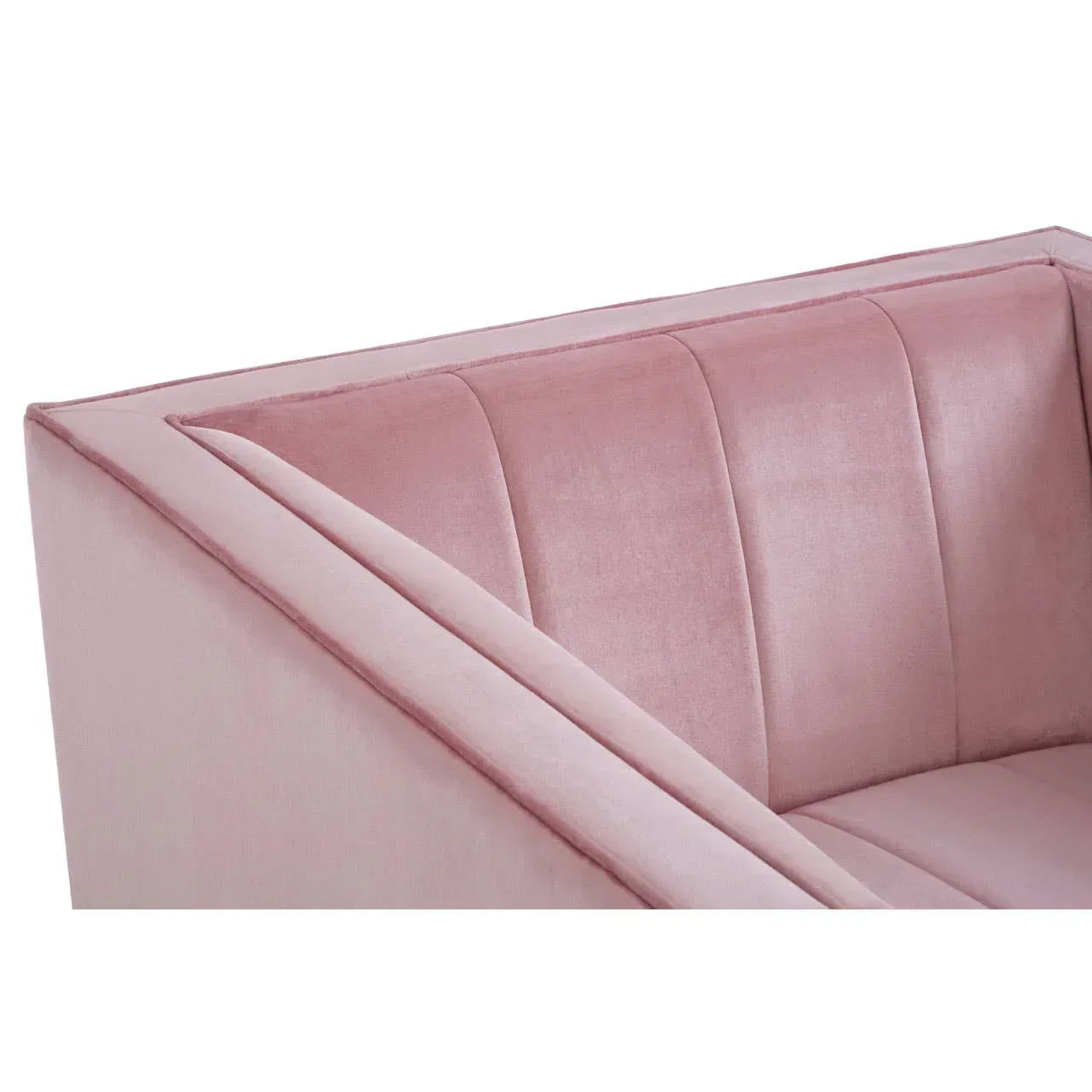 Close view of blush pink velvet sofa with vertical stitched backrest and angled armrest