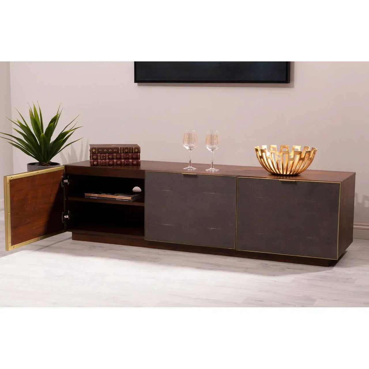 Modern sideboard with dark wood finish, gold accents, open cabinet, and decorative items on top