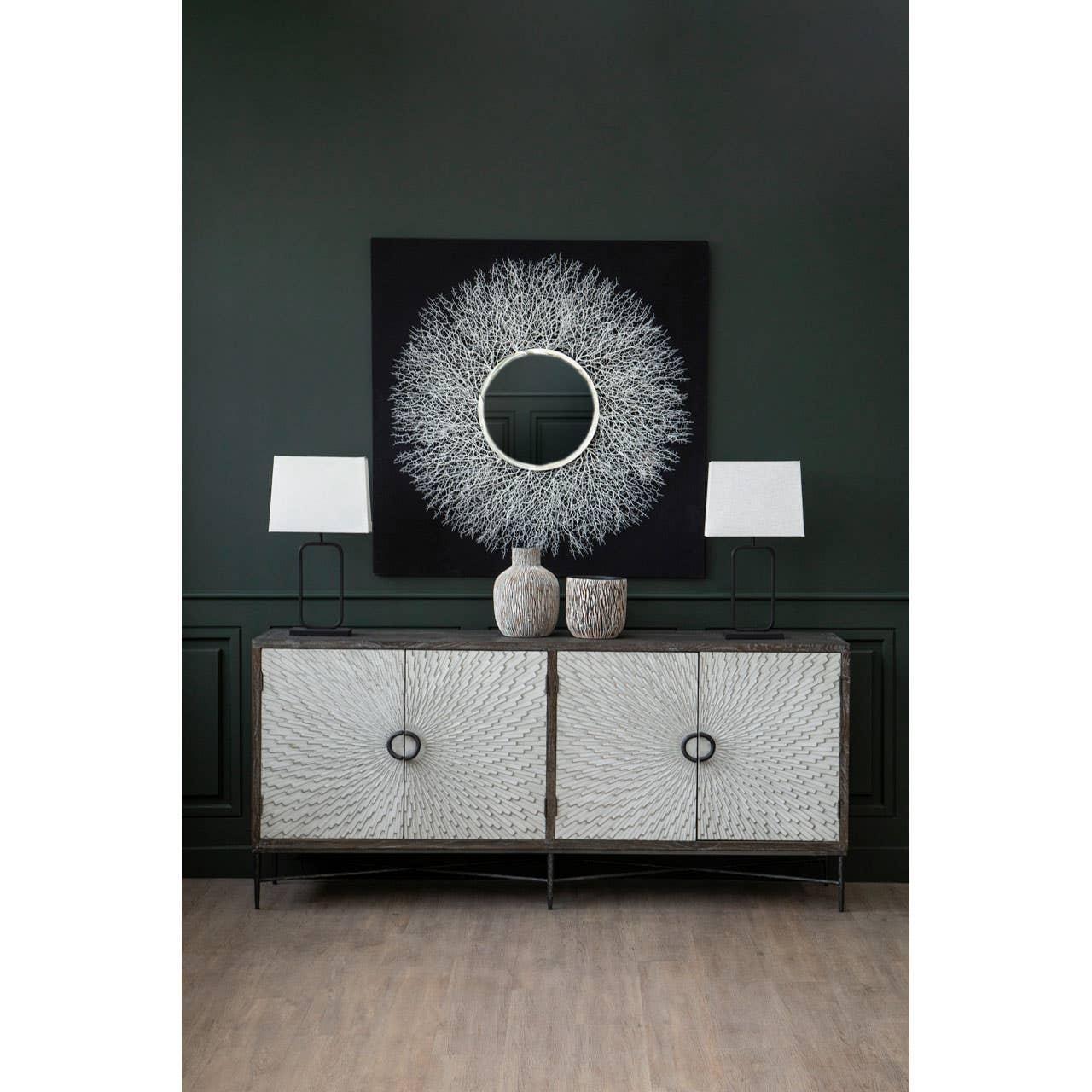 Modern sideboard with textured doors, two table lamps, vases, and abstract wall art