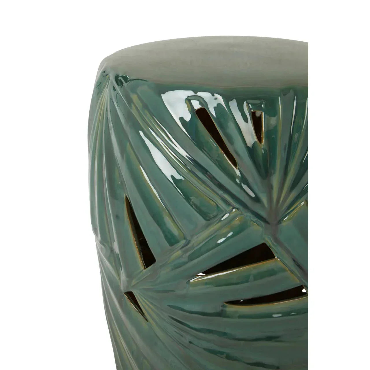 Green ceramic side table with leaf cutout pattern, glossy finish, partial close-up view