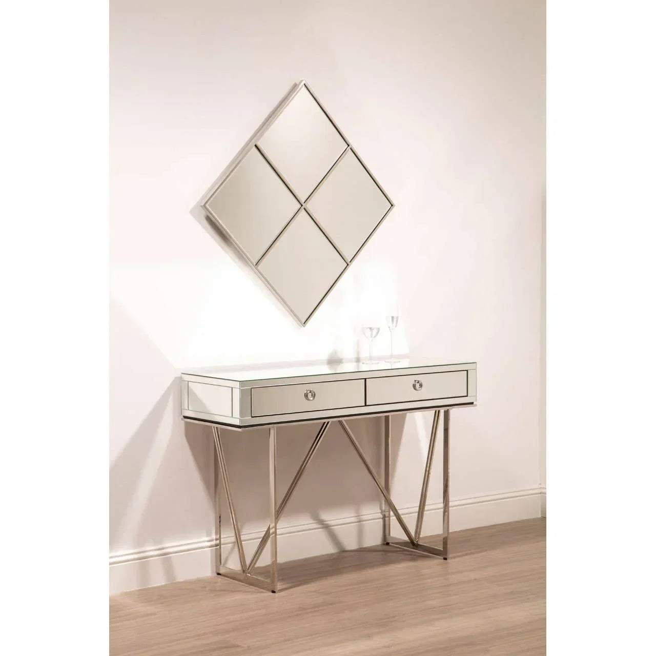 Mirrored console table with two drawers and geometric legs, wall mirror above, on wood floor
