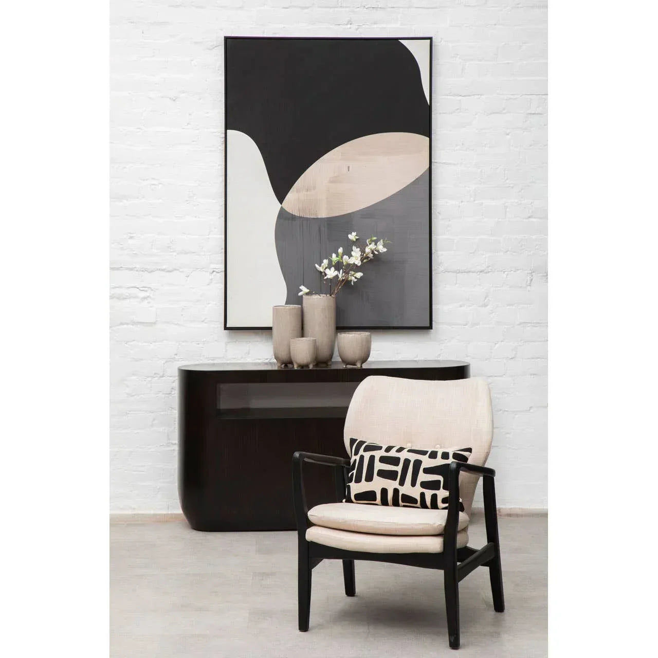 Modern accent chair with cream upholstery, black frame, and geometric cushion in living room